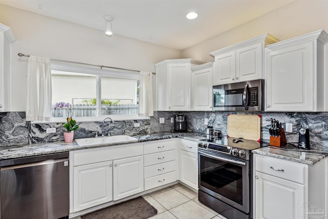 kitchen featuring appliances with stainless steel finishes, tasteful backsplash, sink, and white cabinets