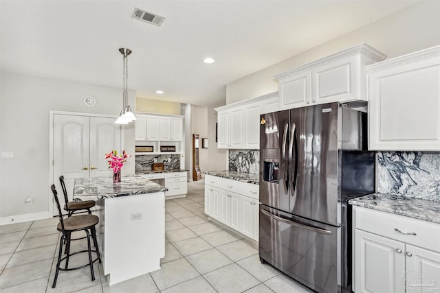 kitchen with decorative light fixtures, backsplash, stainless steel fridge with ice dispenser, a center island, and white cabinetry