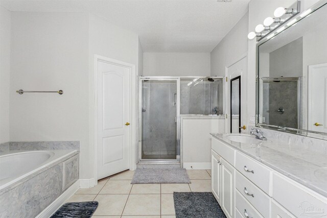 bathroom with separate shower and tub, tile patterned floors, vanity, and a textured ceiling