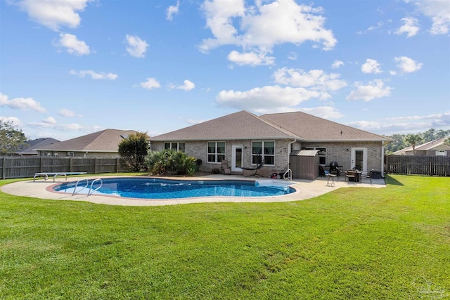 view of pool with a patio area, a diving board, and a lawn