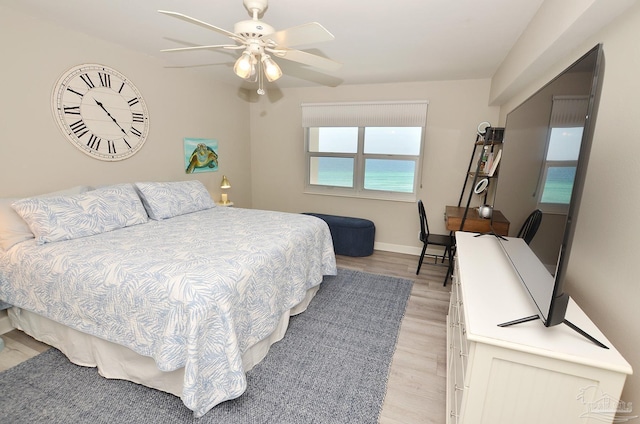 bedroom featuring baseboards, ceiling fan, and light wood-style floors