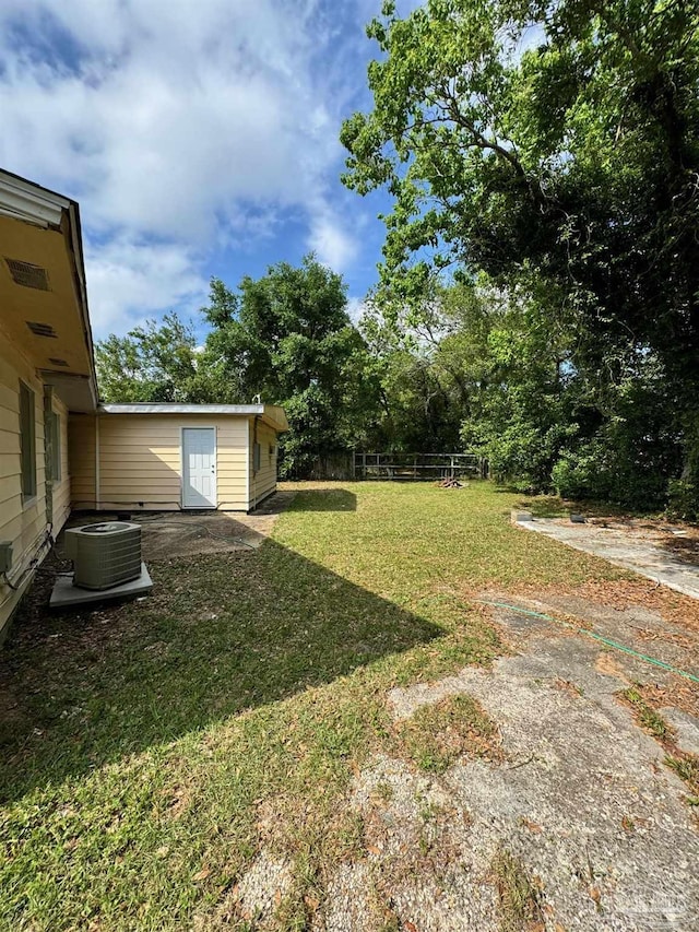 view of yard featuring fence and central air condition unit