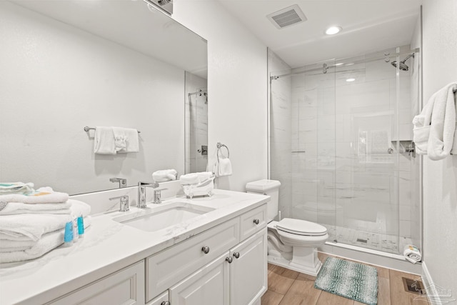 bathroom with vanity, toilet, and a shower with shower door