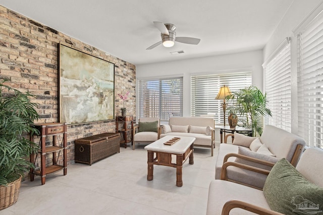 living room featuring ceiling fan and brick wall