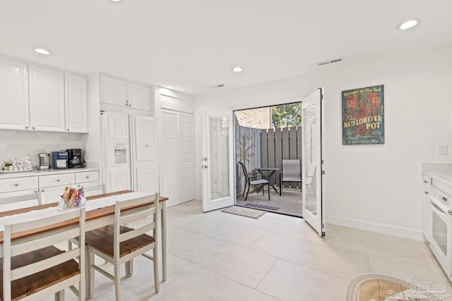 kitchen with light tile patterned floors, tasteful backsplash, white cabinetry, and french doors