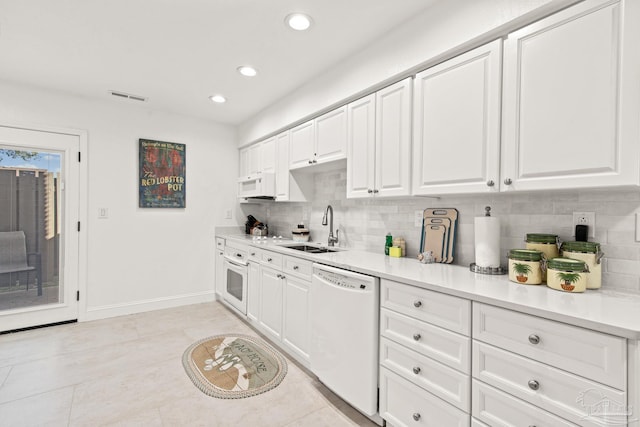 kitchen with white cabinets, white appliances, light tile patterned flooring, and sink