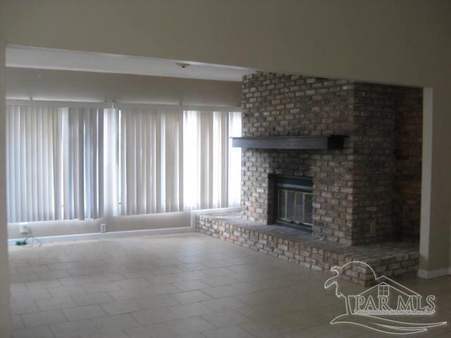 unfurnished living room with tile patterned flooring and a brick fireplace