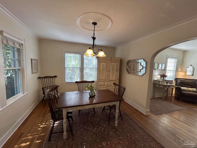 1726 N 15th Ave, Pensacola, FL 32503 - dining space with arched walkways, crown molding, wood finished floors, and baseboards