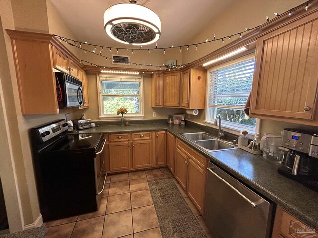 1726 N 15th Ave, Pensacola, FL 32503 - kitchen featuring appliances with stainless steel finishes, a sink, dark countertops, light tile patterned floors, and lofted ceiling