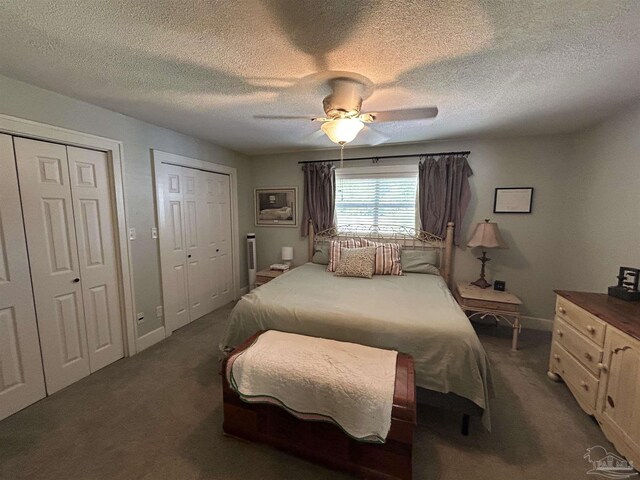 1726 N 15th Ave, Pensacola, FL 32503 - bedroom with dark colored carpet, two closets, baseboards, a textured ceiling, and a ceiling fan