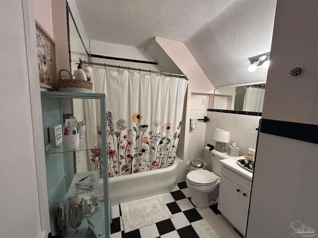 1726 N 15th Ave, Pensacola, FL 32503 - bathroom featuring tile patterned floors, a textured ceiling, tile walls, toilet, and shower / bathtub combination with curtain