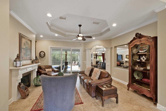 2926 Greystone Dr, Pace, FL 32571 - living room with decorative columns, crown molding, arched walkways, a glass covered fireplace, and a raised ceiling