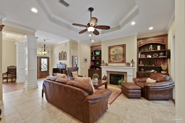 2926 Greystone Dr, Pace, FL 32571 - living room featuring decorative columns, ceiling fan, a tray ceiling, a premium fireplace, and ornamental molding