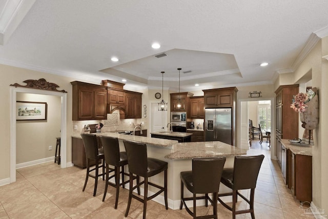 2926 Greystone Dr, Pace, FL 32571 - kitchen with appliances with stainless steel finishes, an island with sink, a raised ceiling, a breakfast bar, and ornamental molding