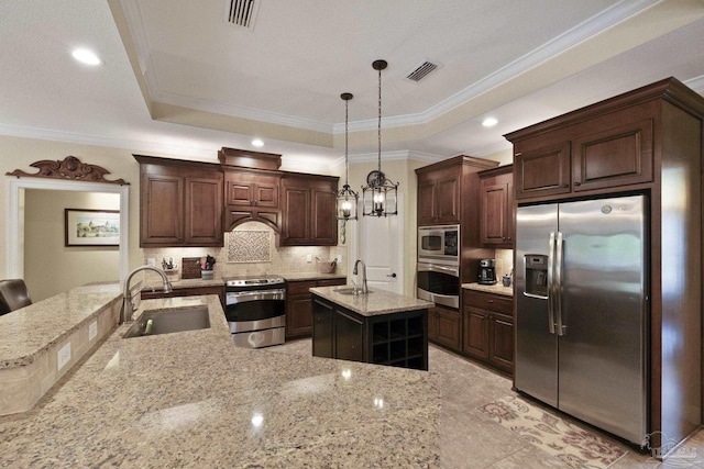 2926 Greystone Dr, Pace, FL 32571 - kitchen with appliances with stainless steel finishes, a sink, a tray ceiling, ornamental molding, and a center island with sink