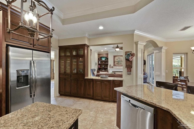 2926 Greystone Dr, Pace, FL 32571 - kitchen featuring stainless steel appliances, decorative columns, arched walkways, a chandelier, and light stone counters