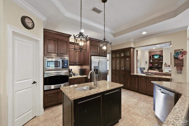 2926 Greystone Dr, Pace, FL 32571 - kitchen with appliances with stainless steel finishes, a sink, a tray ceiling, a kitchen island with sink, and pendant lighting