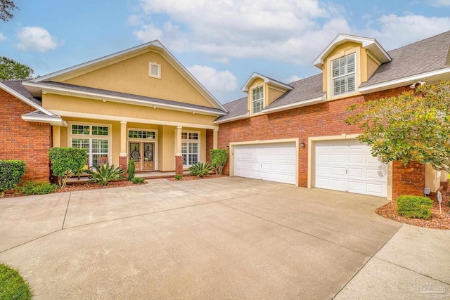 2926 Greystone Dr, Pace, FL 32571 - traditional-style home with concrete driveway, stucco siding, roof with shingles, and covered porch