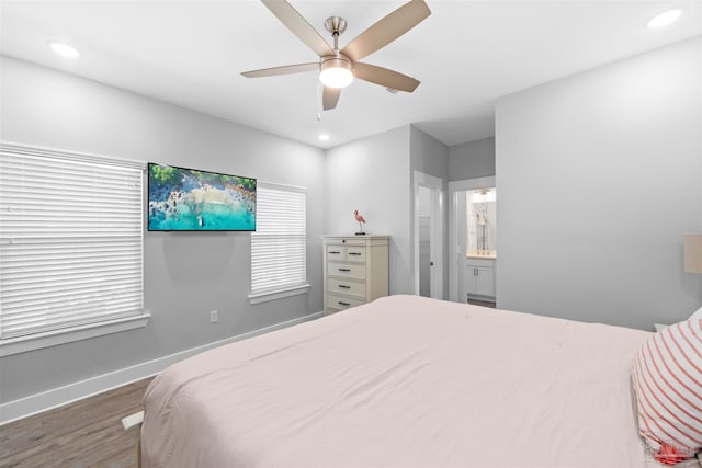 bedroom featuring ceiling fan, ensuite bath, and dark hardwood / wood-style floors