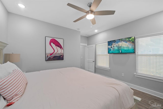 bedroom featuring multiple windows, dark hardwood / wood-style flooring, and ceiling fan