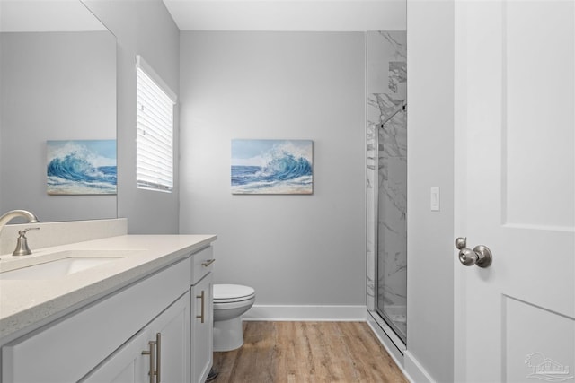 bathroom featuring hardwood / wood-style flooring, walk in shower, vanity, and toilet