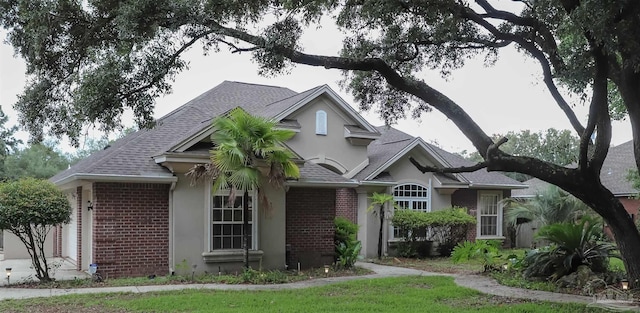 4436 Soundside Dr, Gulf Breeze, FL 32563 - view of front of home with brick siding, a shingled roof, and stucco siding