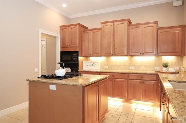 4436 Soundside Dr, Gulf Breeze, FL 32563 - kitchen with black appliances, light stone countertops, a center island, backsplash, and crown molding