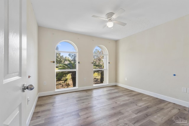 empty room with ceiling fan and light hardwood / wood-style floors