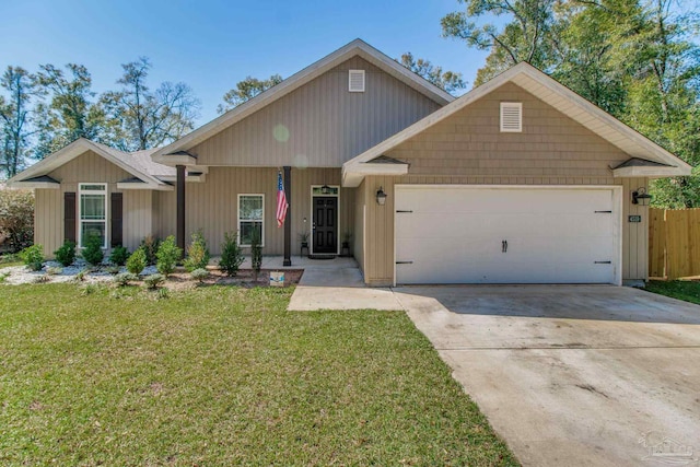 view of front of home with a front yard, fence, a garage, and driveway