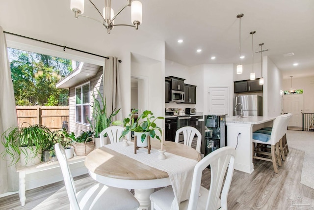 dining area with visible vents, recessed lighting, light wood-type flooring, and an inviting chandelier