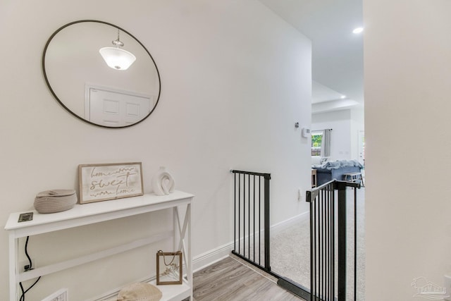 corridor featuring light wood-type flooring and baseboards