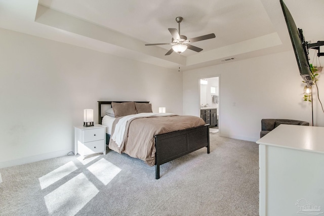 bedroom featuring baseboards, a tray ceiling, light carpet, and visible vents