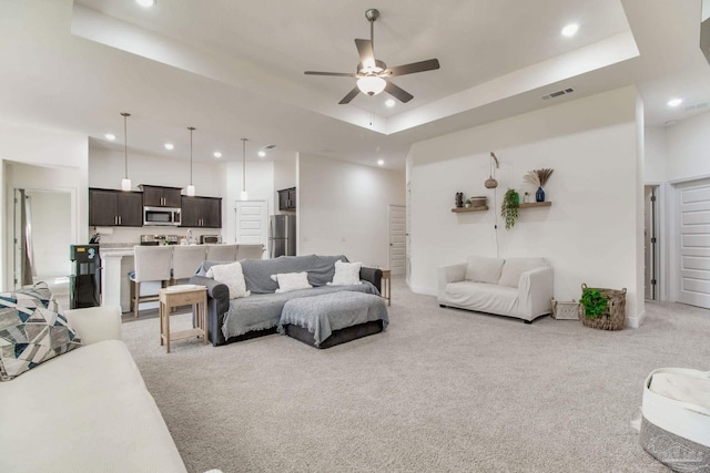 living room with visible vents, light carpet, recessed lighting, a raised ceiling, and ceiling fan