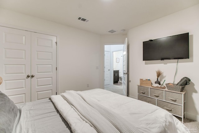 bedroom with carpet, visible vents, and a closet