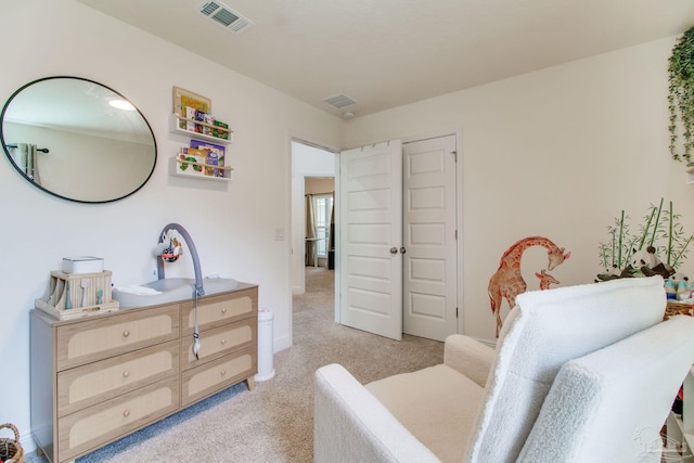 bedroom featuring a sink, visible vents, and light carpet