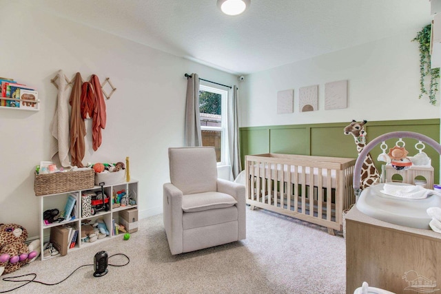 carpeted bedroom with a nursery area