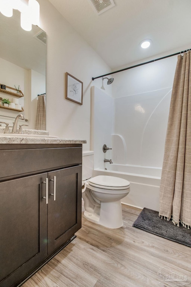 full bath with vanity, shower / tub combo, toilet, and wood finished floors