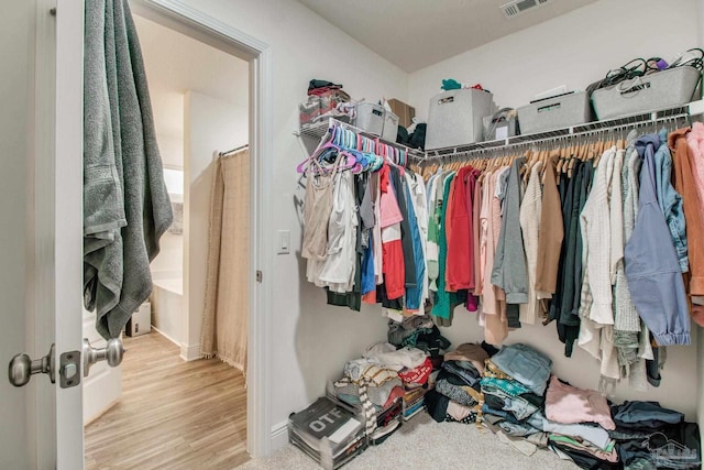 walk in closet with wood finished floors and visible vents