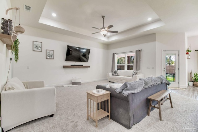 living area featuring a ceiling fan, baseboards, visible vents, recessed lighting, and a raised ceiling