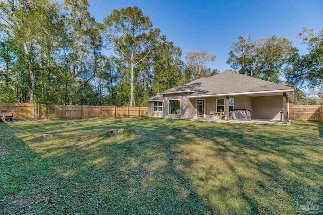 rear view of house with a patio, a lawn, and a fenced backyard