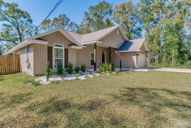 view of front of property with an attached garage, driveway, a front lawn, and fence