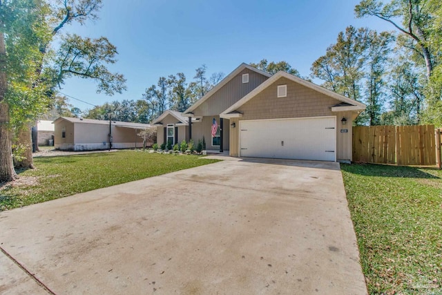 view of front facade featuring a front yard, an attached garage, fence, and driveway