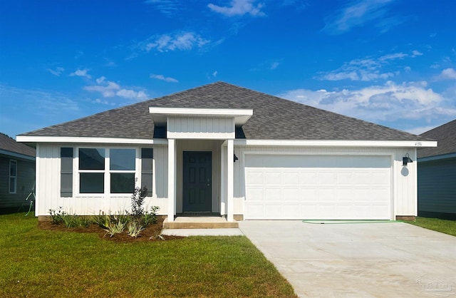 ranch-style home featuring concrete driveway, roof with shingles, an attached garage, and a front yard