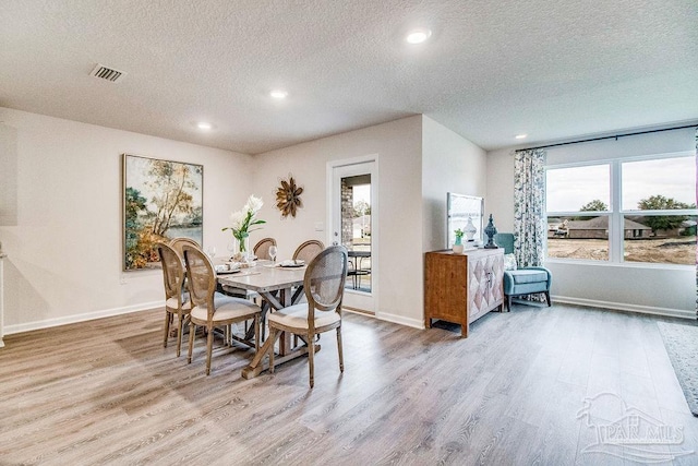 dining area with a wealth of natural light, baseboards, and wood finished floors