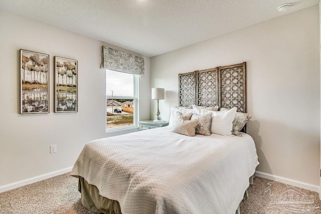 carpeted bedroom with baseboards and a textured ceiling