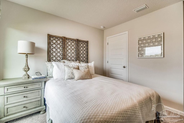 bedroom with a textured ceiling and visible vents