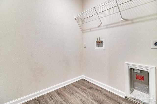 clothes washing area with laundry area, baseboards, dark wood-type flooring, hookup for a washing machine, and hookup for an electric dryer