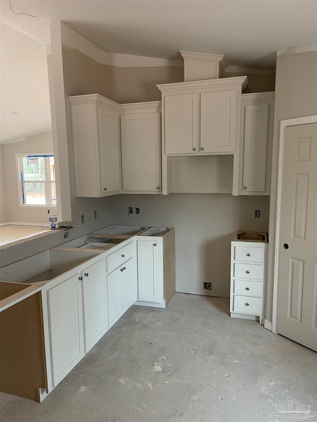 kitchen featuring vaulted ceiling and white cabinets