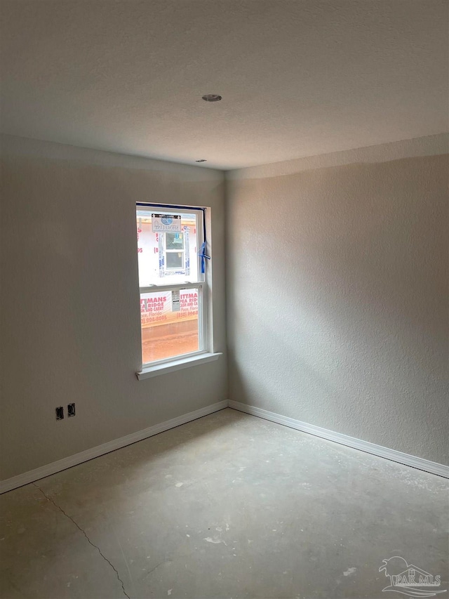 unfurnished room featuring concrete flooring