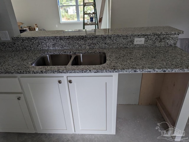 kitchen with white cabinetry and light stone counters